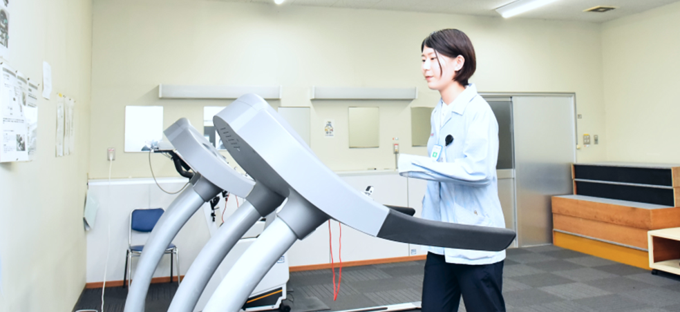 ランニングマシンを使う女性社員の写真