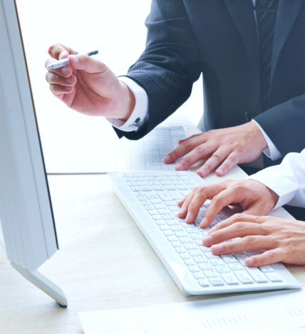 パソコンに入力する人と、ペン先をモニターに向けている人の手元の写真