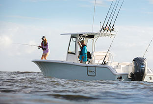 船外機がついているボートの上でたち、漁の仕掛けを回収する2人の写真