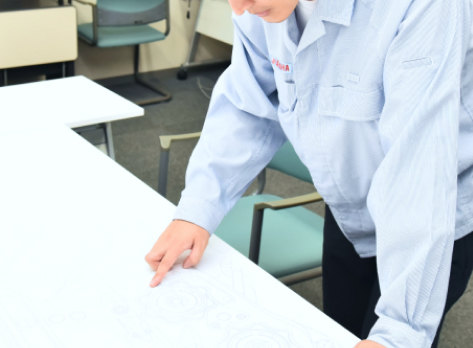 机の上の設計図と手の写真