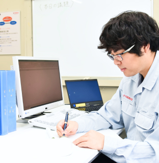 男性社員がデスクで業務している写真