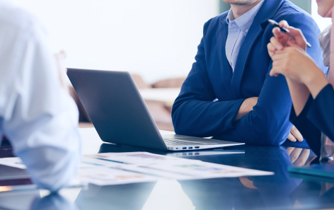 社員3名がパソコンを囲んで会議している写真