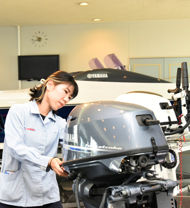 船外機を見る女性社員の写真